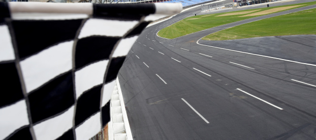 view from finish line with checkered flag waving at the race track.