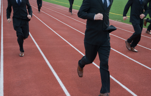 Anonymous businessmen run a race against each other on running track