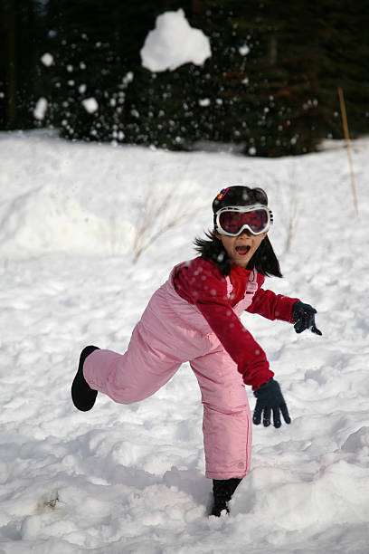 jovem garota guerra de bola de neve - snowball snow play throwing - fotografias e filmes do acervo