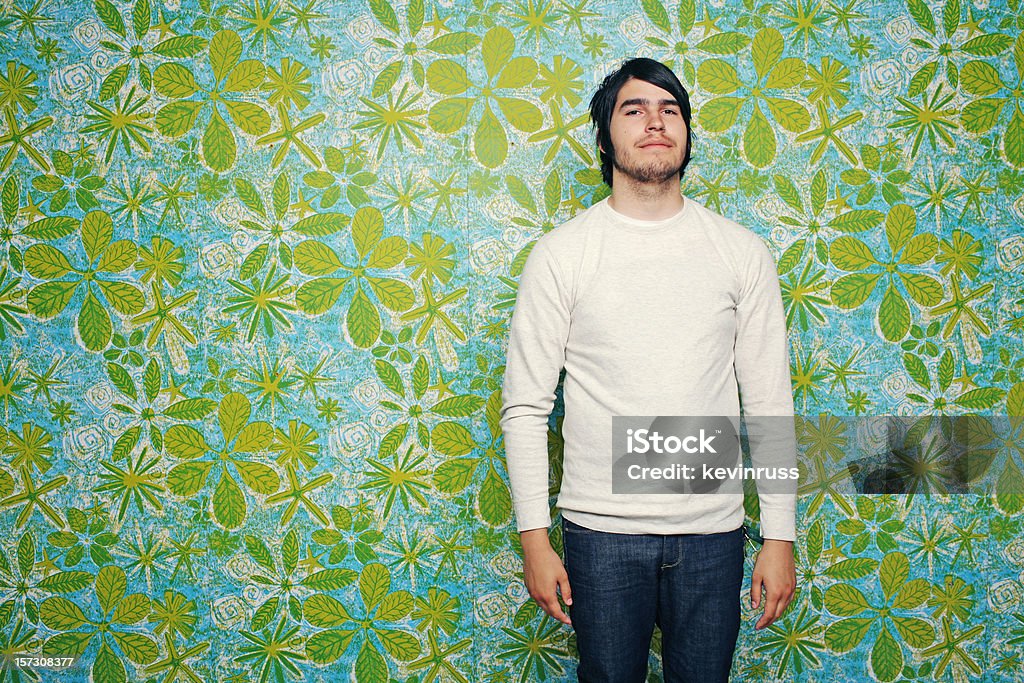 Jeune homme sur le mur de papier peint rétro bleu vert - Photo de Motif floral libre de droits