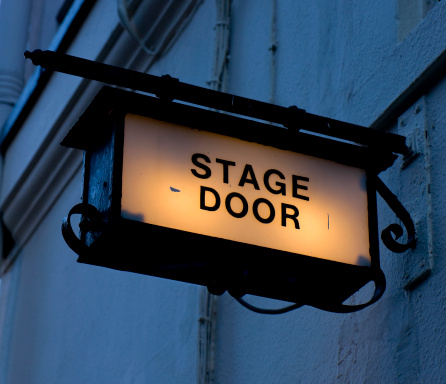 An illuminated sign above a London theatre's stage door. 