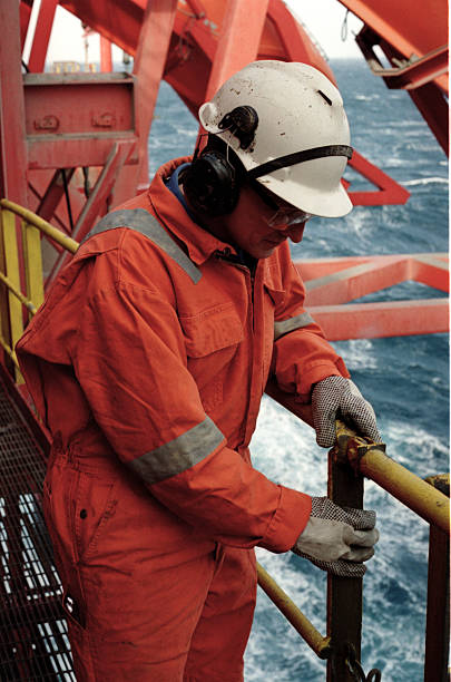 istock Man in orange uniform and white helmet working on an oil rig 157309274