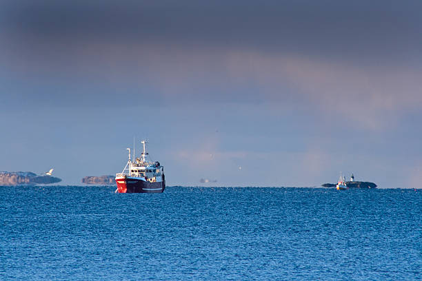 A red fishing trawler sets out for a fishing trip in Cape cod Bay and beyond.