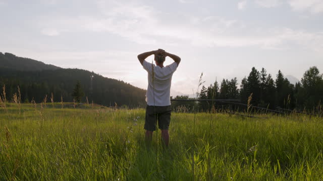 Senior man walks into mountain meadow