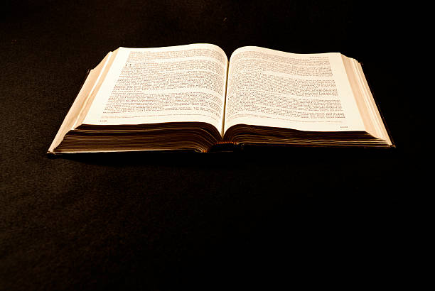 Open Bible on Black Background with Copy Space stock photo