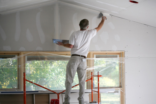 Applying mud to freshly taped sheetrock.