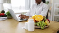 istock Fruits and medicine being placed on desk at nutritionist's 1573099610