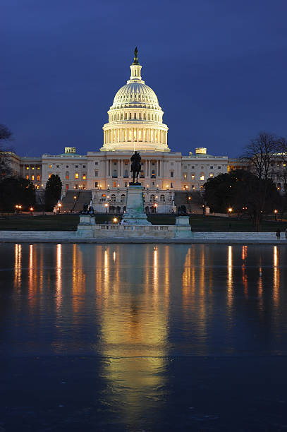 istock The U.S. Capitol lit up at night over water with reflection 157310065