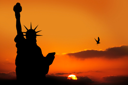 The Statue of Liberty Silhouetted by sunset in New York, USA