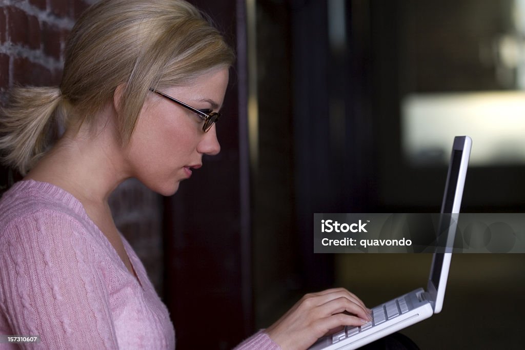 Красивая блондинка Молодая женщина, набрав на ноутбук в коридоре, Copyspace - Стоковые фото 20-29 лет роялти-фри