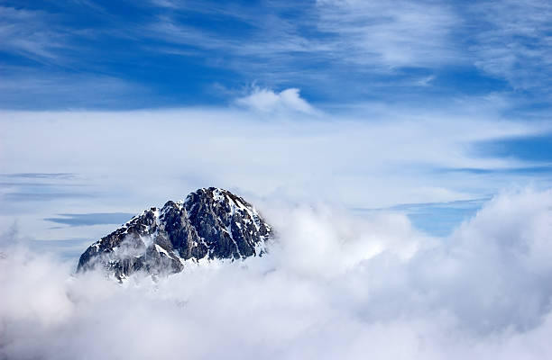 Mountain peak above the clouds stock photo