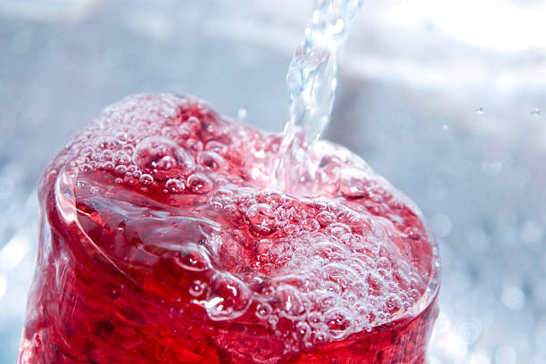 Close-up of a bubbly red drink A refreshing juice drink mixed with ice cold spring water. Shallow DOF, with main focus on front surface of drink. red drink stock pictures, royalty-free photos & images