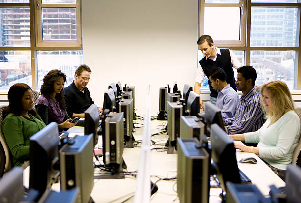 adult education: mature students working in a computer laboratory stock photo