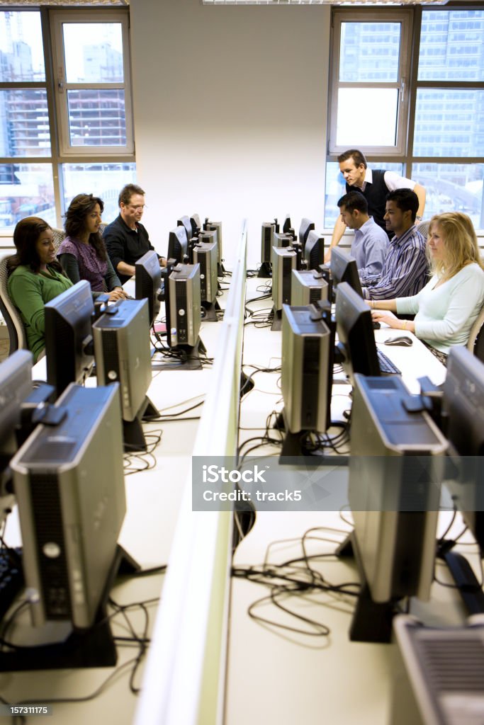 Educação para adultos: Um grupo de estudantes maduros em aula de informática - Foto de stock de Curso de treinamento royalty-free