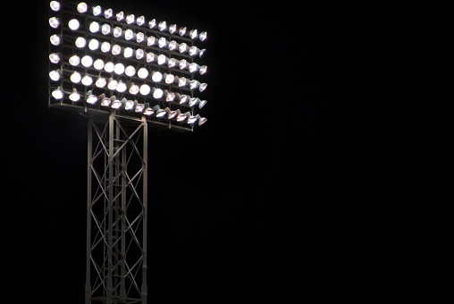 Bright lights shining for a night game at a sports stadium.
