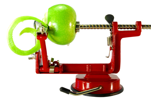 Apple peeler with a green half peeled apple. Isolated with clipping path.