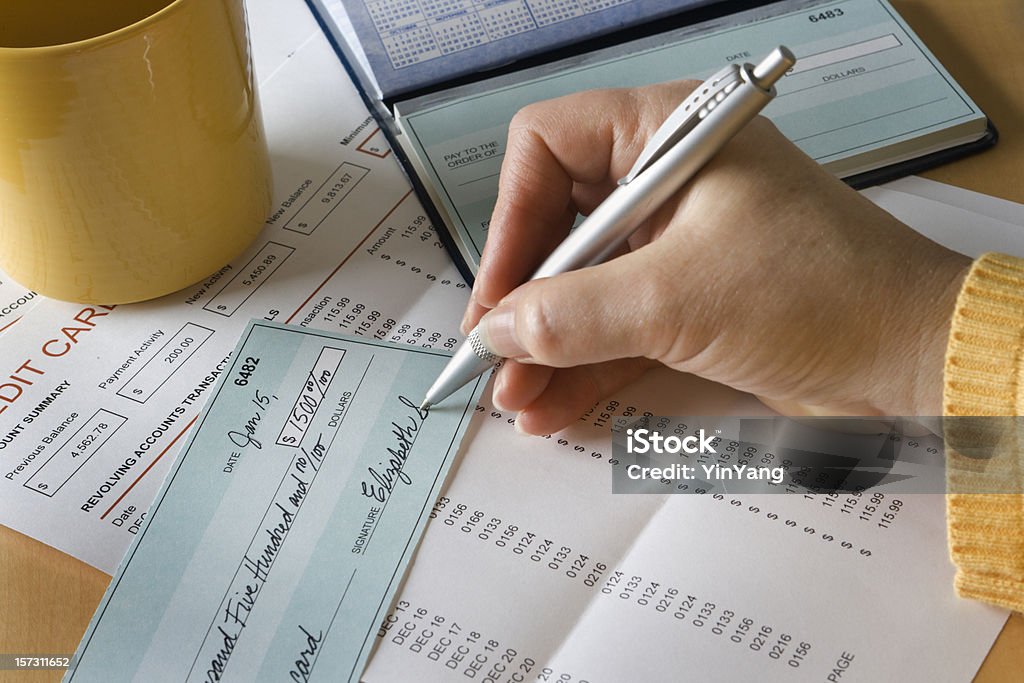 Writing Check Paying Credit Card Debt and Bills for Finance Subject: Paying credit debt with personal check. All documents including personal checks and credit card invoice are fictitious for privacy reason. Check - Financial Item Stock Photo