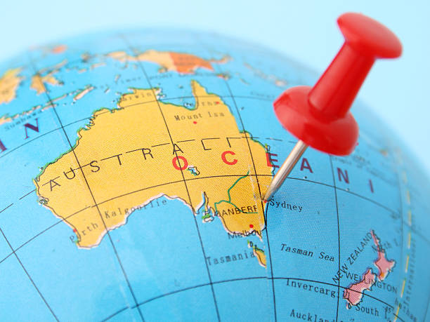 Australia Pushpin pointing Sidney in cheap plastic globe. Shallow depth of field australasia stock pictures, royalty-free photos & images
