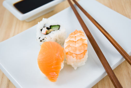 Traditional Japanese sushi and chopstick on white plate and soy sauce. Shallow depth of field.