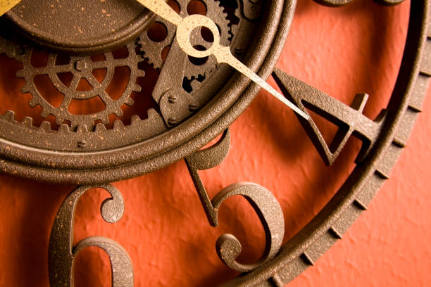 istock Time. Close-up of metal, rustic clock on red, rust wall. 157313304