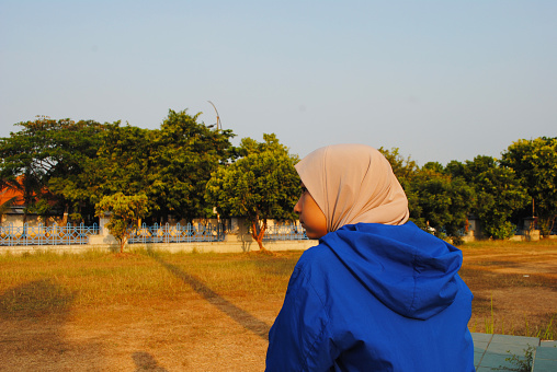 An Indonesian teenager doing muscle stretching in the morning. Outdoor sport activity.