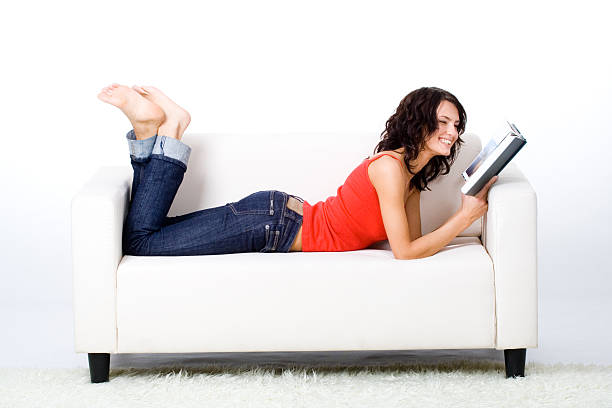 Femme lisant un livre sur le canapé-lit - Photo