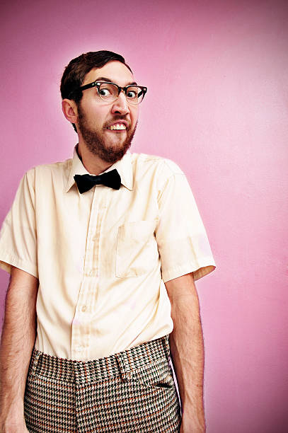Nerd Guy With Glasses, Bow Tie, and Pink Background A man making a silly face and dressed in goofy clothes.  Vertical with copy space. comb over stock pictures, royalty-free photos & images