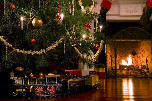 Toy train under the Christmas tree A toy train under a Christmas tree. miniature train stock pictures, royalty-free photos & images