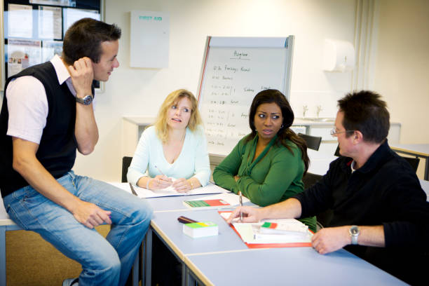 istock adult education: mature students debate in class with their teacher 157314123