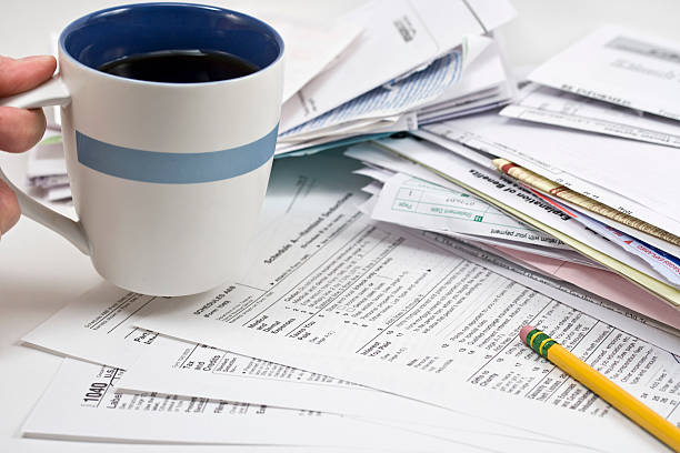 Drinking coffee while doing taxes stock photo