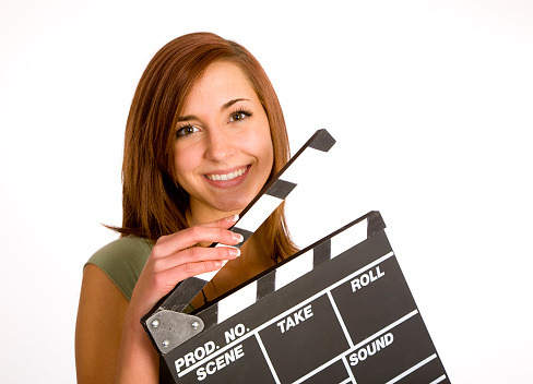 A young woman holding a film slate against a white background.