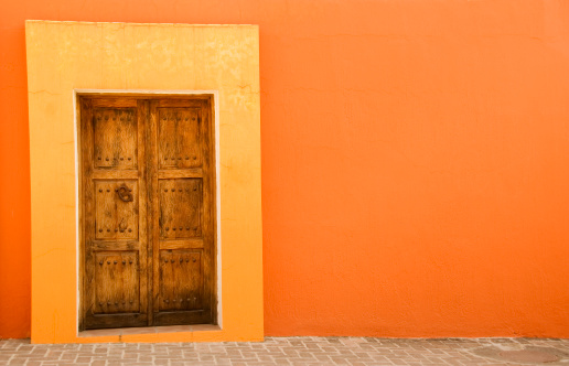 Orange wall with fancy door.