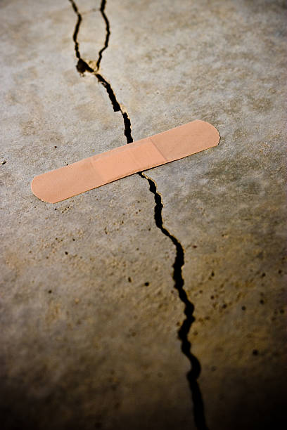 A cracked surface with a band aid stock photo