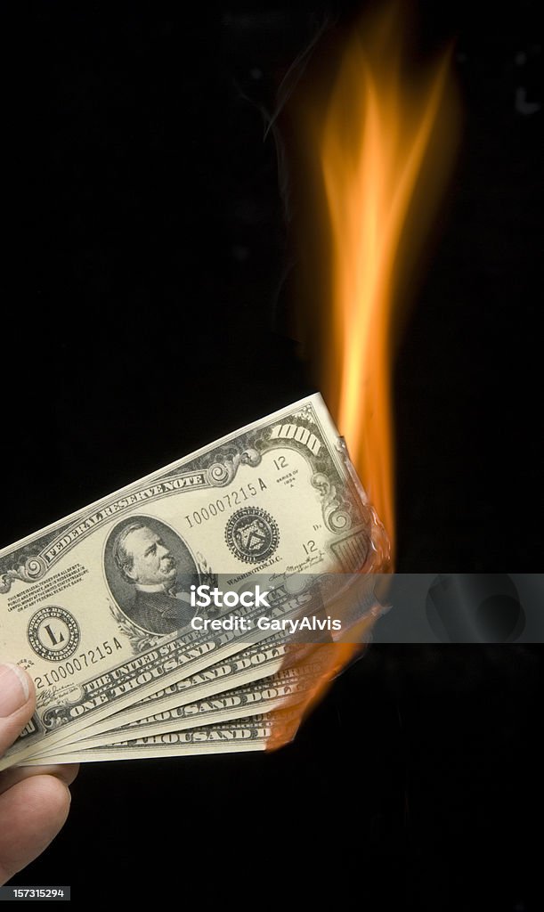 Fingers holding burning thousand dollar bills-money to burn  Accidents and Disasters Stock Photo