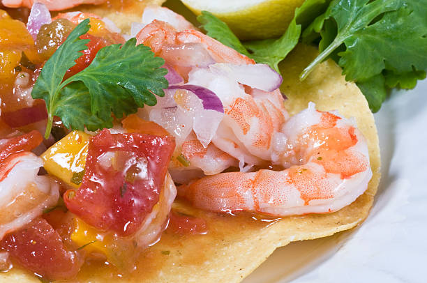 Shrimp Ceviche Tostada Tropical mexican shrimp cocktail, made with mango, onions, fresh tomatoes and lemon over a corn tostada shrimp cocktail stock pictures, royalty-free photos & images