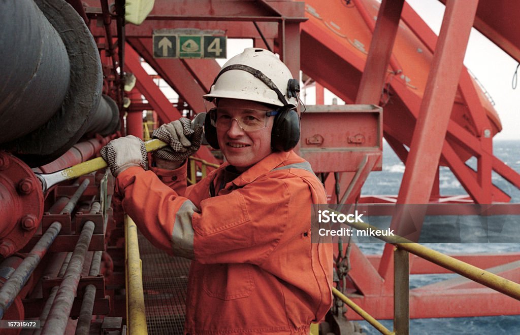 Man Dressed in Orange Working on an Oil Rig - Royalty-free Offshore platform Stockfoto Man Dressed in Orange Working on an Oil Rig - Royalty-free Offshore platform Stockfoto