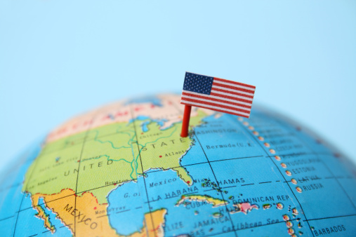 United States flag pointing Washington in cheap plastic globe. Shallow depth of field, focus on flag