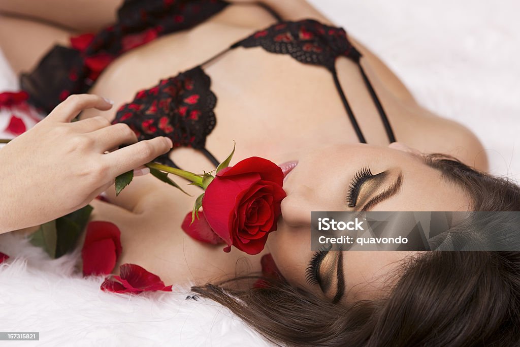 Bela e jovem mulher Sexy em Lingerie cheirando uma rosa de Dia dos Namorados - Foto de stock de Sutiã royalty-free