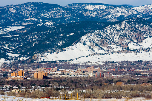 Boulder Colorado against the snow covered backdrop of the Rocky Mountains in winter time.