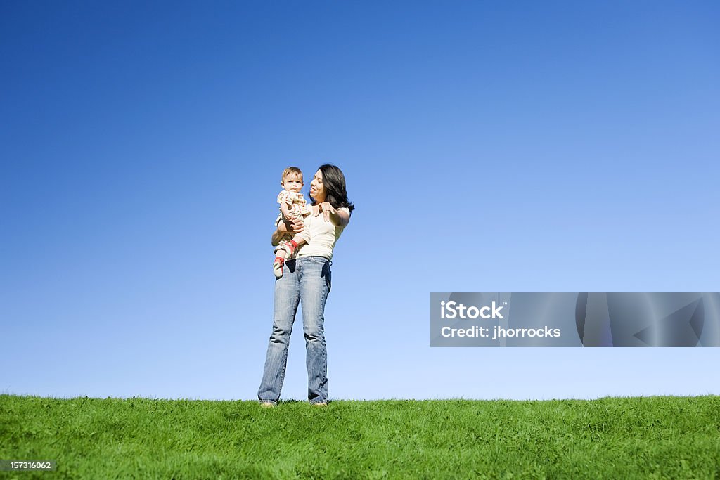 Madre e hijo en césped Hill - Foto de stock de Agarrar libre de derechos
