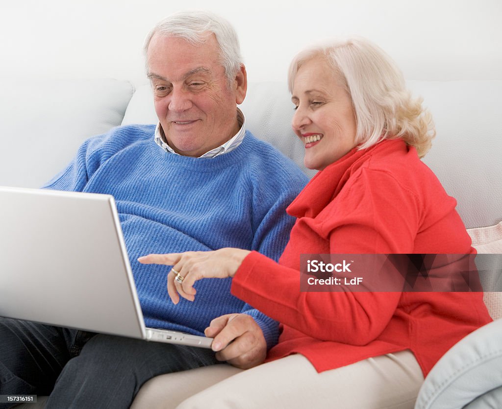 Seniorzy surfing internet z laptopa w - Zbiór zdjęć royalty-free (60-64 lata)