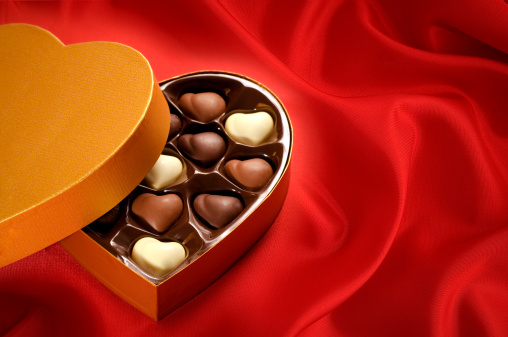 Golden chocolates box on red satin background. on horizontal composition.
