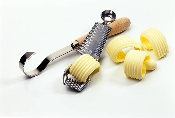 close up of two butter knives and butter curls