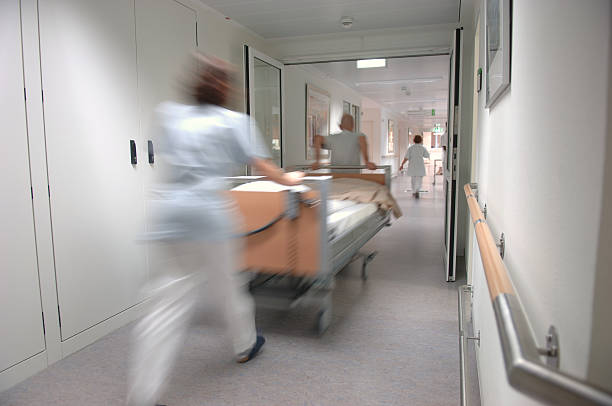 Nurses pulling a sickbed stock photo