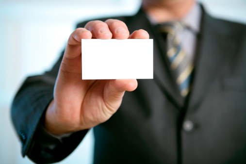 Businessman showing his business card. Shallow depth of field - focus on fingers and card. You can just add your text there.