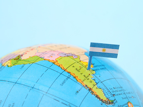 Argentinian flag pointing Buenos Aires in cheap plastic globe. Shallow depth of field