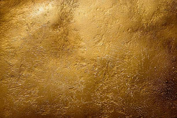 Stone gold wall under a faint source of light stock photo