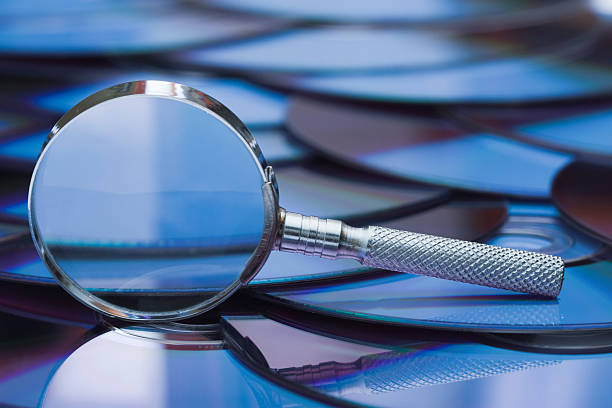 istock Magnifying glass sitting atop CD ROM disks 157316700