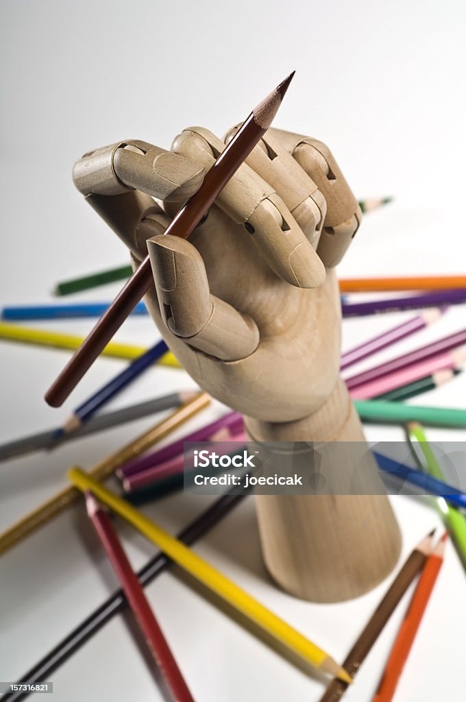 Colored Pencils with Wooden Hand Wooden Artist Hand posing with a colored drawing pencil/ Acute Angle Stock Photo