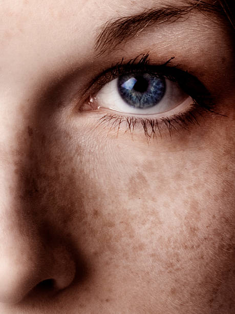 close-up of woman's blue eye y su de pecas en mejilla - sensory perception eyeball human eye eyesight fotografías e imágenes de stock